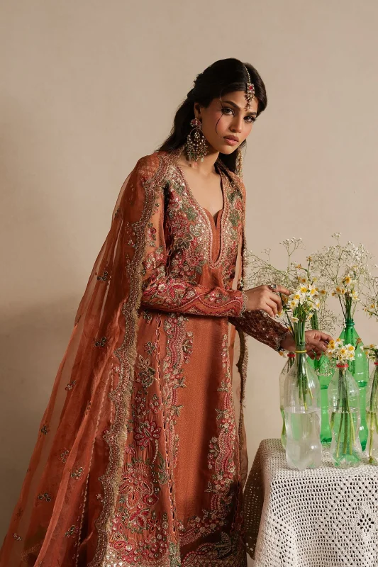 Model in a rust embroidered raw silk and organza three-piece with dupatta