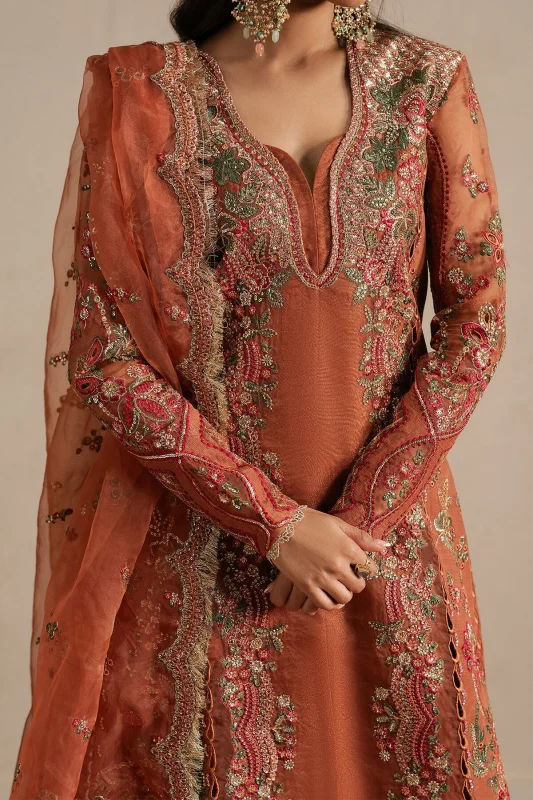 Close-up of intricate embroidery on rust fabric
